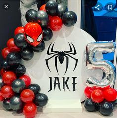 spiderman balloon decoration with the number 5 on it and balloons in front of it