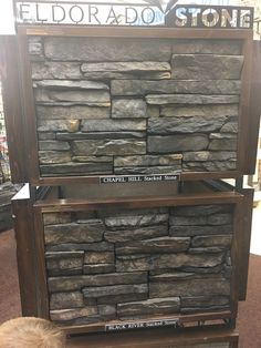 a young boy looking at a display case made out of stacked stone blocks in a store