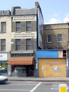 an old building with boarded up windows on the side of it's street corner