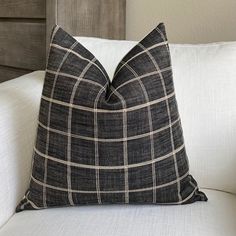 a black and white plaid pillow sitting on top of a couch