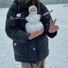 a woman holding a snowman in her hands