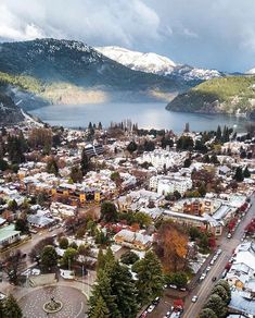 an aerial view of a city with mountains in the background and snow on the ground