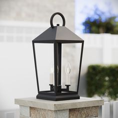 a black lantern with two white candles on it