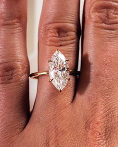 a woman's hand with a ring on it and a diamond in the middle