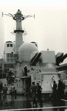 black and white photograph of people walking on the deck of a ship