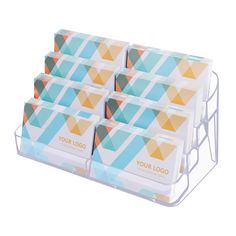 six business cards in a holder on a white background with geometric shapes and the words your logo printed on them