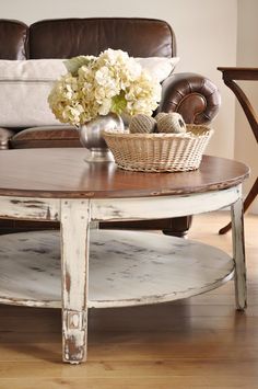 a coffee table with flowers on it in front of a couch