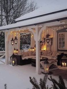 an outdoor covered patio with lights on the ceiling and couches in the snow outside