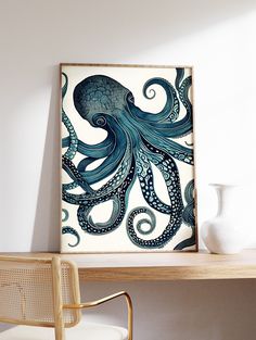 an octopus painting on a white wall above a wooden table with a chair and vase