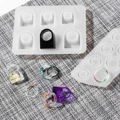 an ice tray with several different types of ring molds next to it on a table