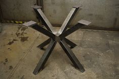 a metal sculpture sitting on top of a cement floor