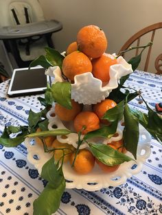 an arrangement of oranges in a bowl on a table