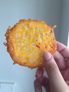 a person holding up a piece of food that looks like an onion fritter