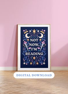 a poster with the words not now i'm reading on it in front of a pink wall