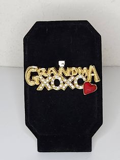 "ITEM DESCRIPTION This is a vintage \"Grandma\" brooch.  It is in gold tone.  There is also XOXO covered in clear rhinestones under the Grandma.  At the end is a red enamel heart. See all photos please...they are part of the description. Markings/Stamps:  Unmarked MEASUREMENTS: 2 Inches Found in photos - please review all photos  **Due to age, there may be a small amount of age flaws not deemed to be worthy of noting...straw marks, bubbles, some scuffing, some particles...as typical with age/pro Clear Rhinestones, Antique Items, Vintage Gold, Brooch Pin, Brooches, Gold Tones, Bubbles, Im Not Perfect, Etsy Uk