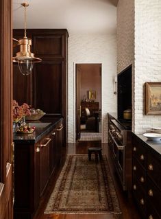 a kitchen with wooden cabinets and an area rug in front of the stove top oven