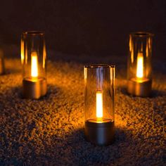 five lit candles sitting on top of a carpet