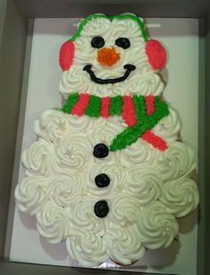 a cupcake decorated like a snowman in a box