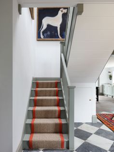 a staircase with carpeted steps leading up to a painting on the wall above it