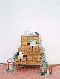 a wooden dresser sitting on top of a tiled floor next to a cake and candles