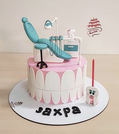 a birthday cake with dental instruments and teeth on the top is decorated in pink and white