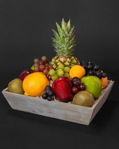 a wooden box filled with lots of different types of fruit on top of each other