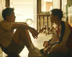 two young men sitting on the floor talking