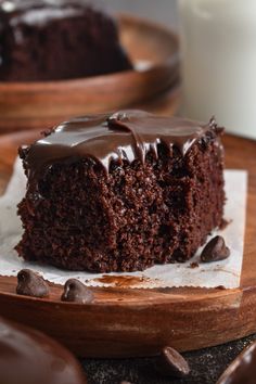 a piece of chocolate cake sitting on top of a wooden plate