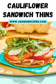 a sandwich with tomatoes, lettuce and cheese on it is sitting on a blue plate