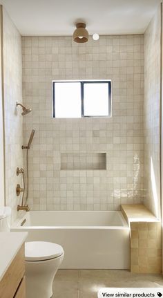 a bathroom with a toilet, bathtub and window in the shower stall is shown