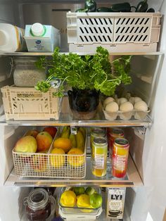 an open refrigerator filled with lots of food and fruit in it's shelves,