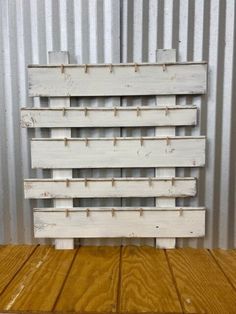 a white wooden crate sitting on top of a wooden floor next to a metal wall