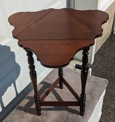 a small wooden table sitting on top of a rug next to a white wall and door