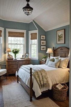 a bedroom with blue walls and white bedding, two windows in the ceiling, wooden furniture