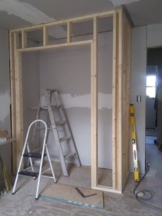 an unfinished room with ladders and construction materials