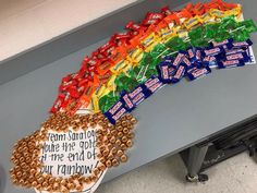 there is a rainbow made out of candy on the counter in front of a sign