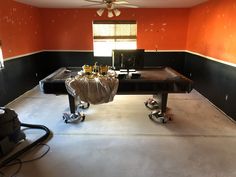 an empty room with a pool table and other items on wheels in front of it