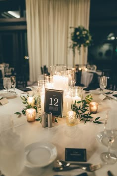 the table is set with candles, plates and place cards for guests to sit at