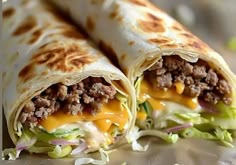 two burritos with meat, cheese and lettuce