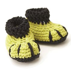 a pair of yellow and black crocheted baby shoes