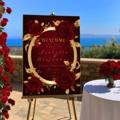 a welcome sign sitting on top of a table next to a vase filled with flowers