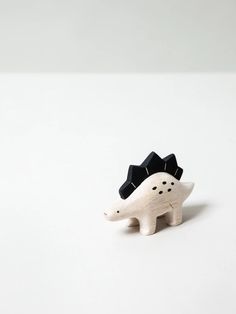 a small white and black toy animal on a white surface with space in the background