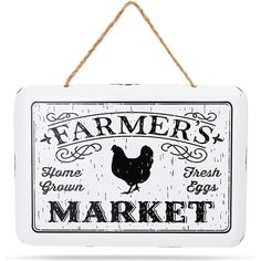 a sign that says farmer's market hanging from a rope on a white wall