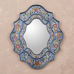 a decorative mirror mounted to the side of a wall next to a pink stucco wall