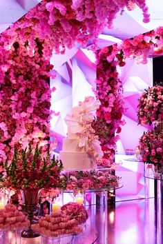 a wedding cake surrounded by pink flowers and candles