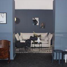 a living room filled with furniture and pictures on the wall next to a table in front of a couch