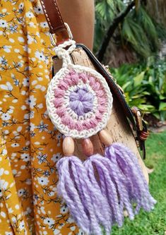 a woman is holding a purse made out of yarn