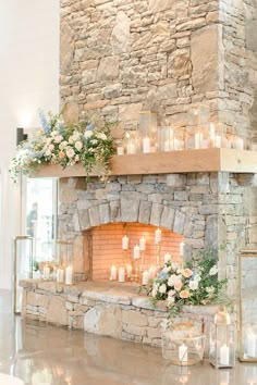 the fireplace is decorated with candles and flowers