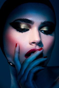 a woman with dark makeup and red nails