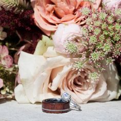 two wedding rings sitting on top of flowers